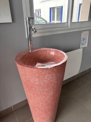 un lavabo rose dans un coin de la salle de bains