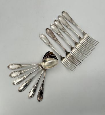 cinq cuillères en argent et une cuillère en argent sur une table blanche
