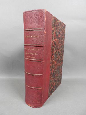 an old book with a red cover sitting on top of a table