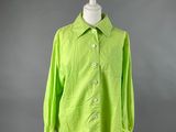 une chemise verte posée sur un mannequin, sur fond gris