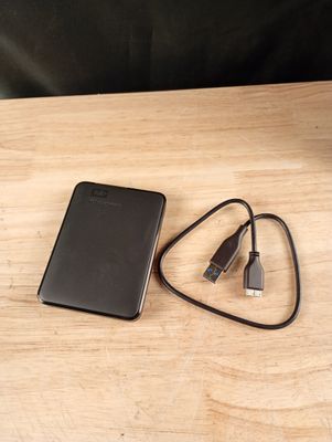 une batterie externe noire et un chargeur posés sur une table en bois