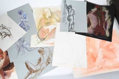 beaucoup de dessins posés sur une table, à côté d'un sac