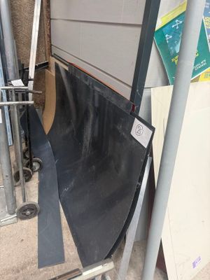 un tas de matériaux de construction posé par terre à côté d'une porte de garage