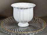 a white cup and saucer sitting on a glass plate