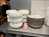 many plates and cups on the counter in the kitchen