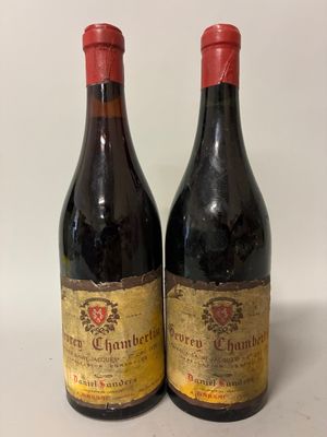 two bottles of red wine sitting next to each other on a table
