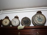 many different clocks on a shelf in a room