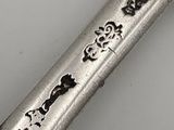 a silver spoon with writing on it sitting on a table