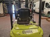 a forklift in a warehouse with other vehicles in the background
