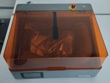 an orange plastic box with screws in it on a white table