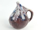 a small brown and blue vase on a white surface