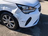 the front end of a white car that has been badly damaged