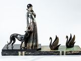statue représentant une femme accompagnée d'un chien et de cygnes, posée sur un socle en marbre