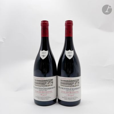deux bouteilles de vin rouge posées l'une à côté de l'autre sur une surface blanche