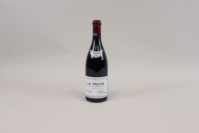 une bouteille de vin rouge posée sur une table blanche