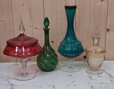 trois vases en verre de couleurs différentes posés sur une table