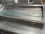 un plan de travail en acier inoxydable surmonté d'une vitrine en verre