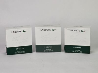 three boxes of lacoste products sitting on a white surface
