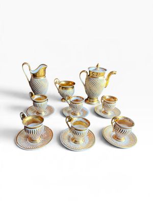 five cups and saucers and a teapot on the table