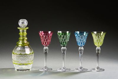 four different colored wine glasses and a decanter sitting on a table