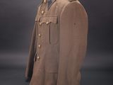 a brown uniform on a mannequin stand against a black background