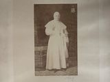 an old photo of a man in a white robe and hat