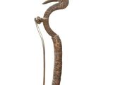 une photo d'une sculpture métallique représentant un serpent, posée sur un socle
