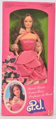 poupée Barbie en robe rose, dans une boîte rose ornée de fleurs roses