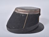 a black hat with a chain around it on a white surface