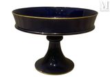 a black and gold cake plate on a pedestal