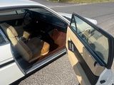 une voiture blanche, porte ouverte, garée sur le bord de la route