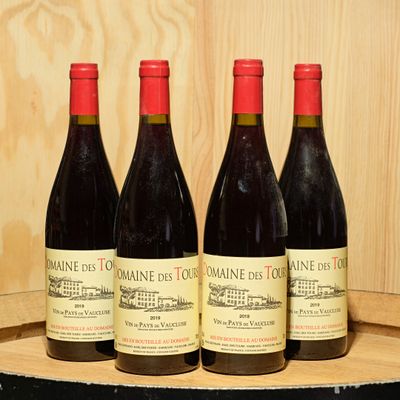three bottles of wine are lined up on a wooden barrel