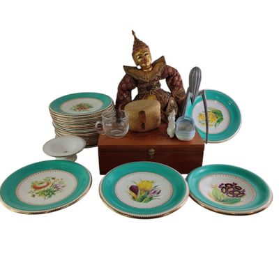une statue représentant une personne assise sur une table, avec des assiettes et des cuillères