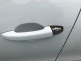 the door handle of a white car with a black handle
