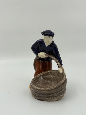 une image représentant une figurine d'un homme assis sur une souche de bois
