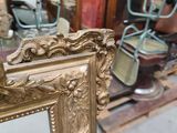 a gold picture frame with a mirror in the middle of it