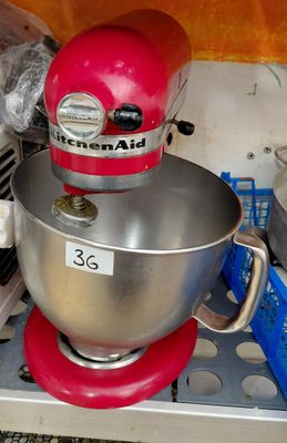 a red mixer sitting on top of a kitchen counter