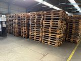 de nombreuses palettes de bois empilées dans un entrepôt