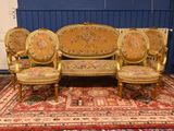a couch and three chairs in a room with a rug