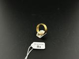 a close up of a gold ring with a tag on it