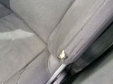 a car seat with a broken arm rest and a pen sticking out of it