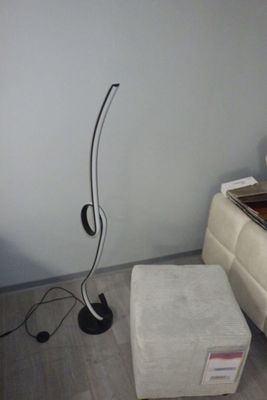 une lampe posée par terre à côté d'un repose-pieds