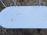 a white table with holes on it sitting in the dirt