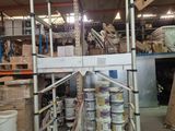a red cart in the middle of a warehouse filled with boxes
