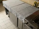 une cuisine équipée d'une cuisinière, d'un four et d'une table recouverte d'un drap