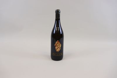 une bouteille de vin posée sur une table blanche