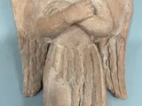 statue of an angel with arms crossed on a blue background