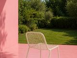 une chaise posée sur un sol rose