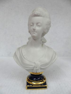 a white bust of a woman with a black base on a white background