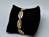 a close up of a gold bracelet on a black pillow